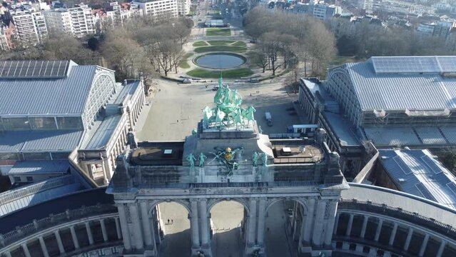 Triumphal arch (Arc de Triomphe) at Cinquantenaire park (Jubelpark) and the streets of Brussels. Drone aerial view