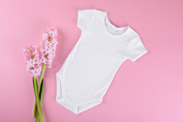 White baby bodysuit on pink pastel color background. Empty place for text or logo on apparel....
