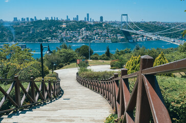 istanbul city bosphorus view from a green park and stairway with wodden bars and continent bridge and buildings