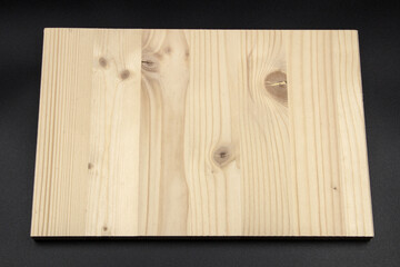 White pine is a material that can also be used in construction. The photo shows a white pine board on a black background.