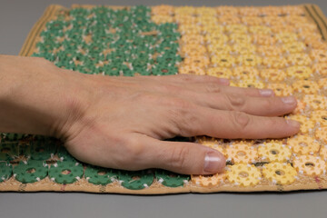 a man's hand lies on the sharp spikes of a medical applicator