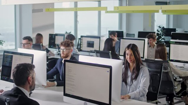 Modern Open Space Corporate Office with Tow Rows off Businessmen and Businesswomen Working on Desktop Computers. Bright Open Space Office with Businesspeople and Salespeople