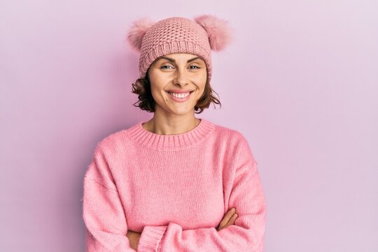 Young brunette woman wearing cute wool cap happy face smiling with crossed arms looking at the camera. positive person.