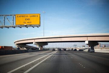 Highway in Las Vegas, going under a bridge and a road sign on the left
