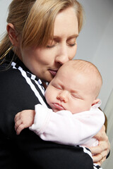 femme blonde caucasienne portant son bébé avec amour 