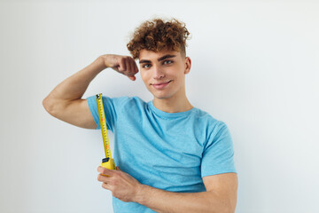 handsome guy yardstick in hand in blue t-shirts isolated background