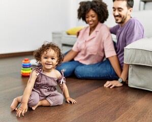 Couple and daughter smiling confident playing with toys sitting on the floor at home