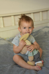 little boy on the bed with a soft toy 