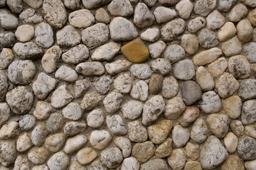 Texture in the form of a concrete wall with large pebbles.