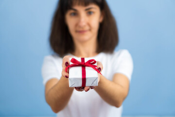 Valentines Day. Woman beauty hands holding small gift package box present wrapped paper with ribbon