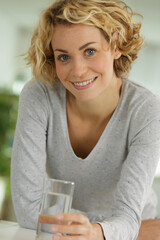 young woman holding glass of water