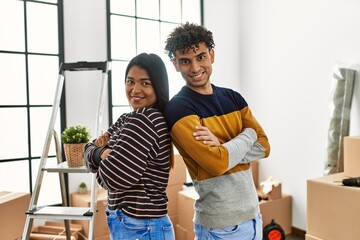 Young latin couple smiling happy standing at new home.