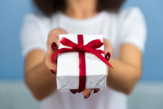 Valentines Day. Woman beauty hands holding small gift package box present wrapped paper with ribbon