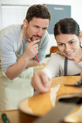 carpenter with female apprentice in workshop