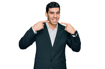 Handsome hispanic man wearing business clothes smiling cheerful showing and pointing with fingers teeth and mouth. dental health concept.