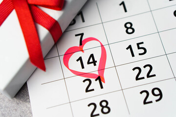 Close up calendar with 14 February date Valentines day with red heart shape marker and gift box
