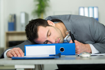 Obraz premium exhausted businessman sleeping on desk