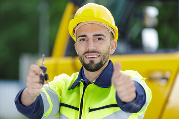 male heavy equipment driver showing key