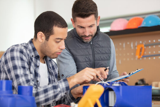 trainee electrician is repairing a device