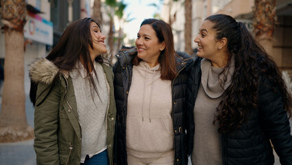 Mother and daugthers smiling confident hugging each other at street
