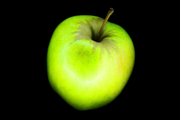 zielone jabłko na czarnym tle. tekstura tła na pulpit lub tapeta. czerń kontrastu dodaje tajemnic do obrazu. świeży owoc, dieta i fit.  - obrazy, fototapety, plakaty