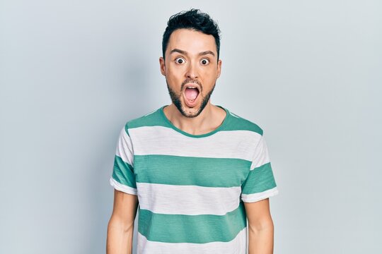 Young hispanic man wearing casual clothes afraid and shocked with surprise and amazed expression, fear and excited face.