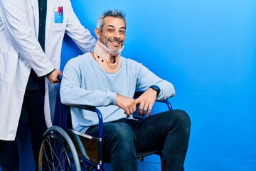 Handsome middle age man with grey hair on wheelchair wearing cervical collar with a happy and cool smile on face. lucky person.