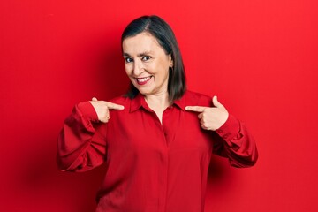 Middle age hispanic woman wearing casual clothes looking confident with smile on face, pointing oneself with fingers proud and happy.