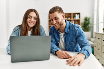Fototapeta na wymiar Young caucasian couple smiling happy using laptop at home.