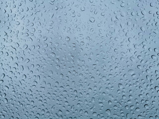 Close up of rain drops texture on a blue glass surface