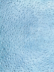 Close up of rain drops texture on a blue glass surface