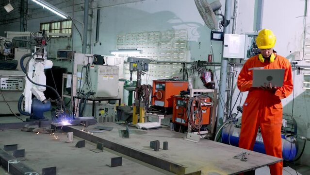 Factory Transformation to Factory 4.0 A woman wearing a blue uniform wearing a helmet to prevent accidents, has started to come up with a chapter on working with machines.