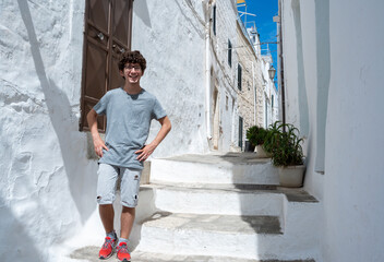 Ostuni, Puglia, Italy. August 2021. A young Caucasian is posing for a souvenir photo in one of the...