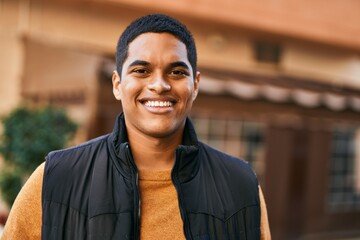 Young latin man smiling happy standing at the city - obrazy, fototapety, plakaty