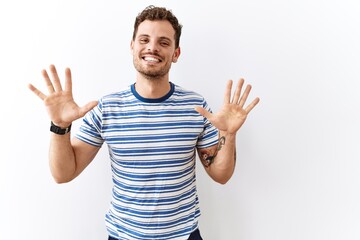 Fototapeta premium Handsome young man standing over isolated background showing and pointing up with fingers number ten while smiling confident and happy.
