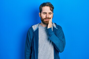 Caucasian man with beard wearing casual sweatshirt touching mouth with hand with painful expression because of toothache or dental illness on teeth. dentist