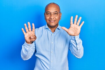 Middle age latin man wearing casual clothes and glasses showing and pointing up with fingers number...