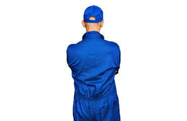 Bald man with beard wearing builder jumpsuit uniform standing backwards looking away with crossed arms