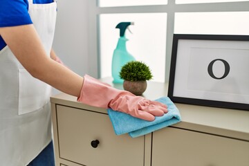 Woman cleaning table using rag and diffuser at home.