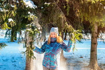 Portrait of a young blonde girl in winter forest in the park. Winter leisure with family.