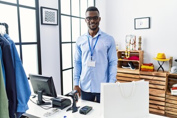 Young african man working as manager at retail boutique with a happy and cool smile on face. lucky person.