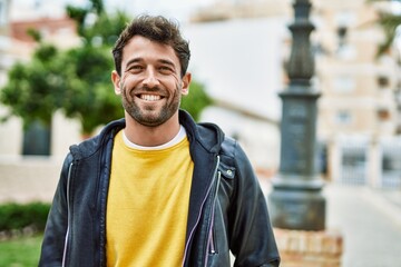 Handsome hispanic man with beard smiling happy outdoors