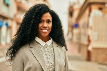 Middle age african american businesswoman smiling happy standing at the city.