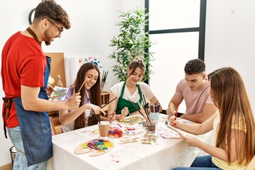 Obraz premium Group of people smiling happy drawing sitting on the table at art studio.