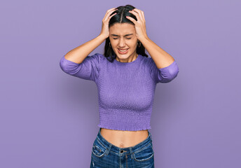 Young hispanic girl wearing casual clothes suffering from headache desperate and stressed because pain and migraine. hands on head.