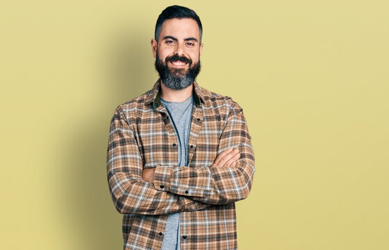 Hispanic man with beard with arms crossed gesture smiling with a happy and cool smile on face. showing teeth.