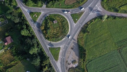 Roundabout traffic of cars and trucks on the circle ring road aerial top view