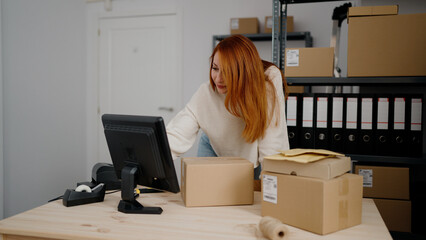 Young redhead woman ecommerce business worker working at office
