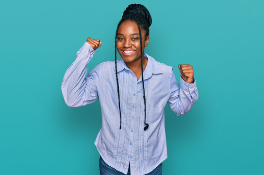Young african american woman wearing casual clothes showing arms muscles smiling proud. fitness concept.