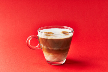  One cup of cappuccino coffee over red background